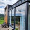 Tiny House  mit Empore – Panorama-Fensterfront über volle Höhe – Zeitgenössischer Chalet-Stil